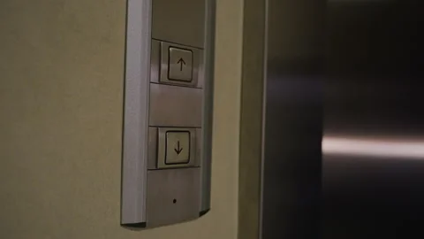 Close-up of Hand Pressing Upward Button on Modern Elevator Panel in Business Stock Footage 306497444