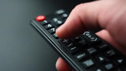 Close-up of a hand pressing the volume up button on a TV remote control Stock Footage 331467545