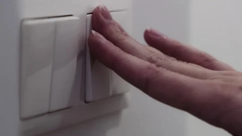 Close-up of a hand pressing a wall switch to turn on a light, emphasizing d.. Stock Footage 309823945