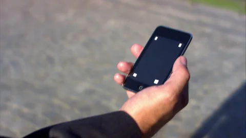 Close Up On Hand Of Professional Man On Mobile Phone on street Stock Footage 130284042