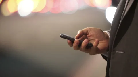 Close up on hand of professional man texting on mobile phone in city at night Stock Footage 49630524