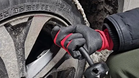 Close-up of hand in protective glove inflating car tire in winter horizonta.. Stock Footage 336177977