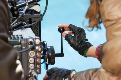 Close-up of a hand pulling focus on a film camera Stock Photos