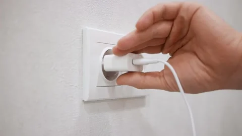 Close-up of hand pulling out white power adapter with USB Video stock 150331850
