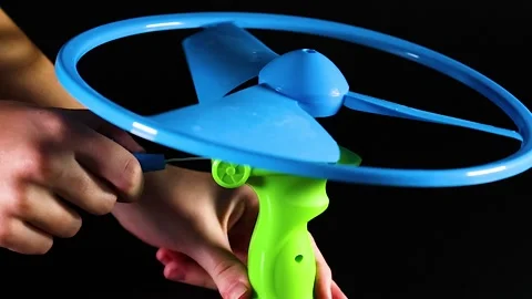 Close Up of Hand Pulling String to Launch Blue Propeller Toy Stock Footage 327432455