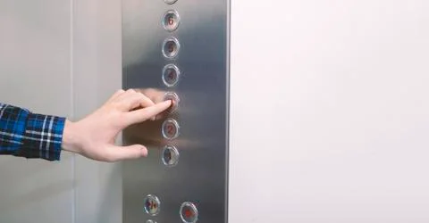 Close up hand pushing a button in the lift elevator cabin Stock Photos