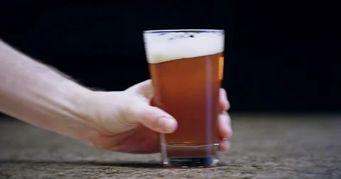 Close up of a hand pushing a pint of beer on a bar into frame 4k Stock Footage 104458275