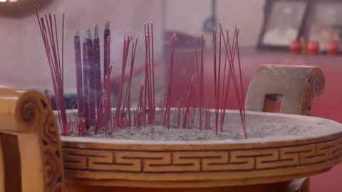 Close-up of hand put Burning Incense Sticks in a Buddhist Temple Stock Footage 326304232