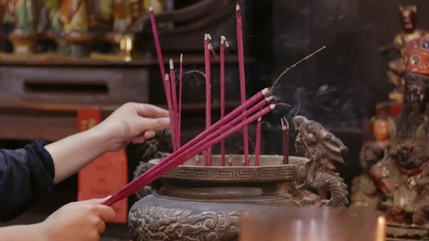 Close-up of hand put Burning Incense Sticks in a Buddhist Temple. unrecogni.. Stock Footage 326304756