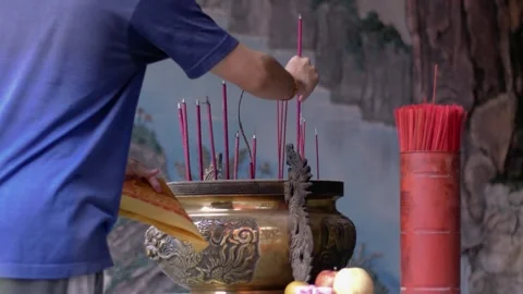 Close-up of hand put Burning Incense Sticks in a Buddhist Temple. unrecogni.. Stock Footage 326305051