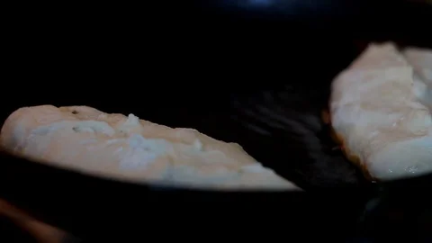 A close-up of a hand put a donut in boiling oil. Stock Footage 128241190