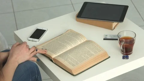 Close up on hand put on text in a book,vintage effect and morning light Stock Footage 71756684