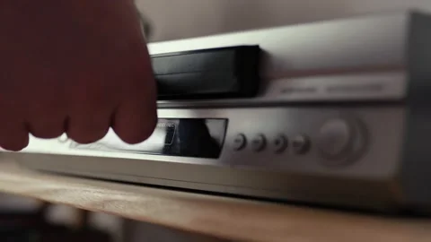 Close up of a hand puting a videotape into video player. Retro vhs cassete. Stock Footage 305182029