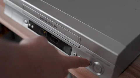 Close up of a hand puting a videotape into video player. Retro vhs cassete. Stock Footage 305183332