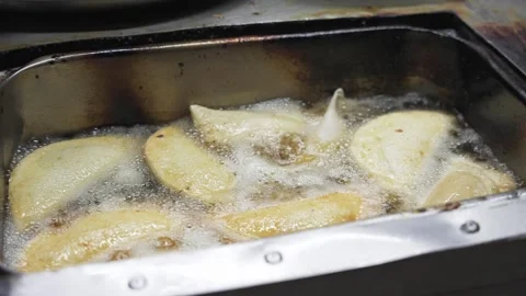 Close up of hand puts fresh cassava flour empanadas in boiling oil. Cooking Stock Footage 270311101