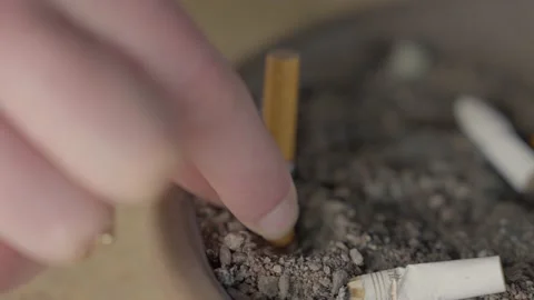 Close up hand puts out cigarette in ash tray Video stock 235948570