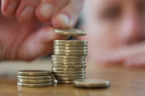 Close-up Of Hand putting a coin to stack of coins. Business Finance and Money Foto stock