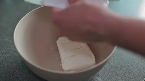 Close-up of a hand putting a piece of cottage cheese into a cup in the kitchen Stock Footage 339096250
