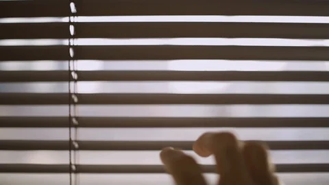 Close up of a hand reaching and opening a crack in the window blinds Stock Footage 109164298