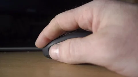 Close-up of a Hand Reaching to Grab a Black Wireless Computer Mouse on a Desk Stock Footage 340318707
