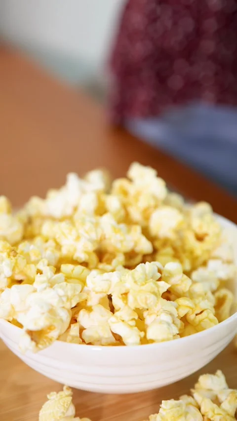 Close Up of Hand Reaching into White Bowl of Buttery Popcorn Stock Footage 336934933