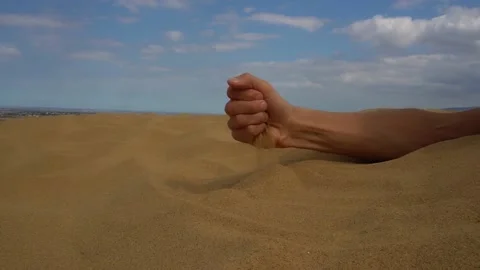 Close-up hand releasing dropping sand. Sand flowing through the hands. 動画素材 162555025