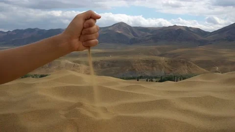 Close-up hand releasing dropping sand. Sand flowing through the hands. Video stock 162653946