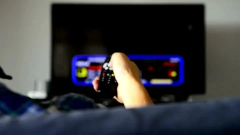 Close-up hand with remote control switches tv channels on background out of.. Video stock 257874550