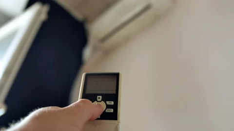Close-up hand with remote control turns on the air conditioner  Video stock 202643913