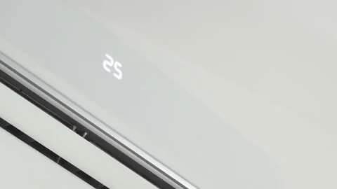 Close up of hand with the remote control turns on the white air conditioner at Stock Footage 260950016