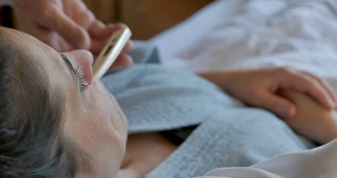 Close up of a hand removing a digital thermometer from a woman's mouth Video stock 107678658