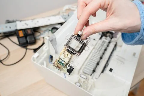 Close-up of a hand removing an inkjet printer printhead during repair and mai Stock Photos