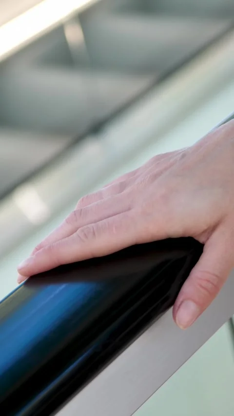 Close-up of hand resting on handrail. Person enjoys smooth ride in escalator Stock Footage 341866424