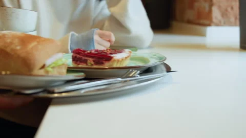 Close up of hand resting on white table with food plate green smartphone and Stock Footage 344871997