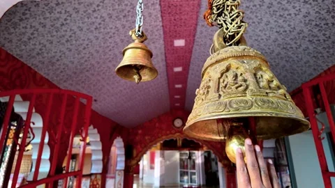 Close Up of a Hand Ringing an Ornate Brass Bell Inside a Hindu Temple Stock Footage 329798130