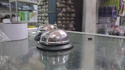 Close Up of Hand Ringing Silver Service Bell on Glass Counter Stock Footage 332196258