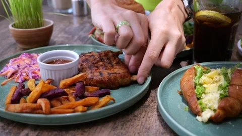 Close up: Hand rips off beef ribs. Large plate with beef ribs, beets, french Stock Footage 244860168