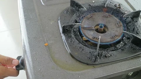 Close up of a hand rotating the control knob to ignite a gas stove burner, .. Stockbeeldmateriaal 333606044