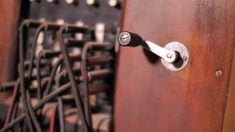 Close up on hand rotating crank on antique telephone exchange Stock Footage 119614095