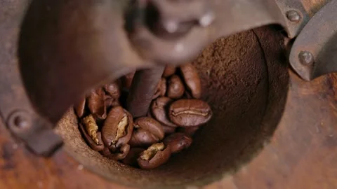 Close-up of hand rotating the handle of vintage coffee mill with roasted beans Stock Footage 229267906