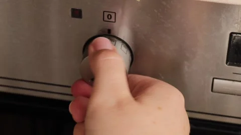 Close up of hand rotating oven control knob to change baking settings on me.. Video stock 319825691