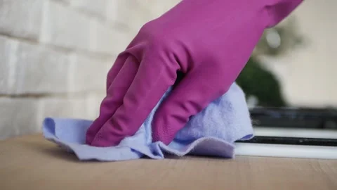 Close up of a hand in a rubber glove with a rag cleaning gas stove. Video stock 130845509