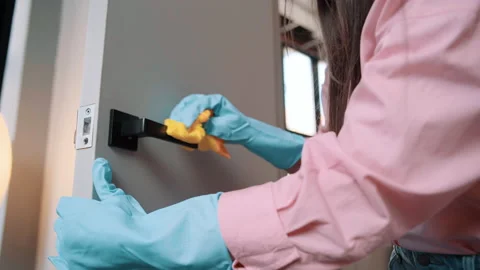 Close-up of a hand in rubber gloves cleaning door knob. Housewife wash doors Video stock 237806130