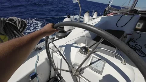 Close-up of a hand on the rudder of a sailing boat and the turning wheel Stock Footage 239351340