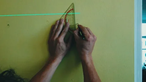 Close up hand with ruler measures distance from lazer pointer on a wall Stock Footage 221023801