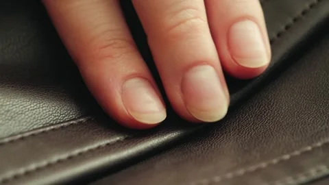 A close-up of a hand running along the seam of a leather jacket to appreciate Video stock 334998863