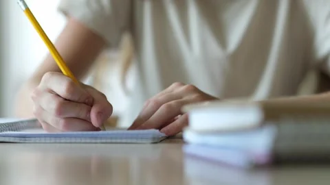 Close up hand of school student writing, child doing homework at home table Stock Footage 316588778