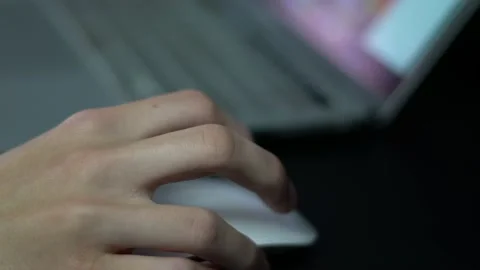 Close up of hand scrolling, clicking a white computer mouse on dark Stock Footage 213831813