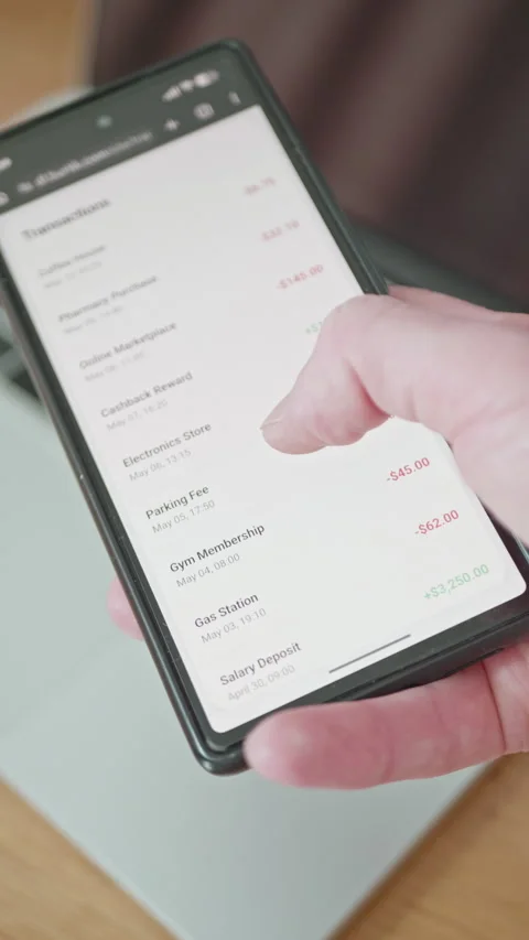 Close-up of hand scrolling through transaction history list on generic mobile 動画素材 335527664