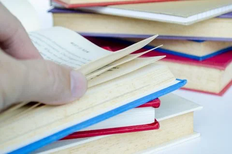 Close up of hand selecting book from vibrant stack with customizable space .. Stock Photos